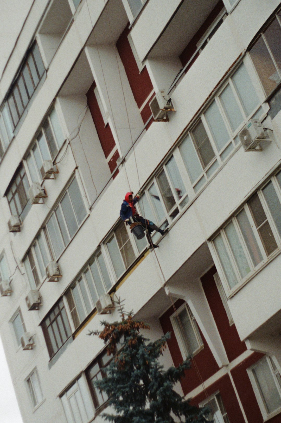 window-cleaner-rappels-down-a-building-facade-6i0di73urdw